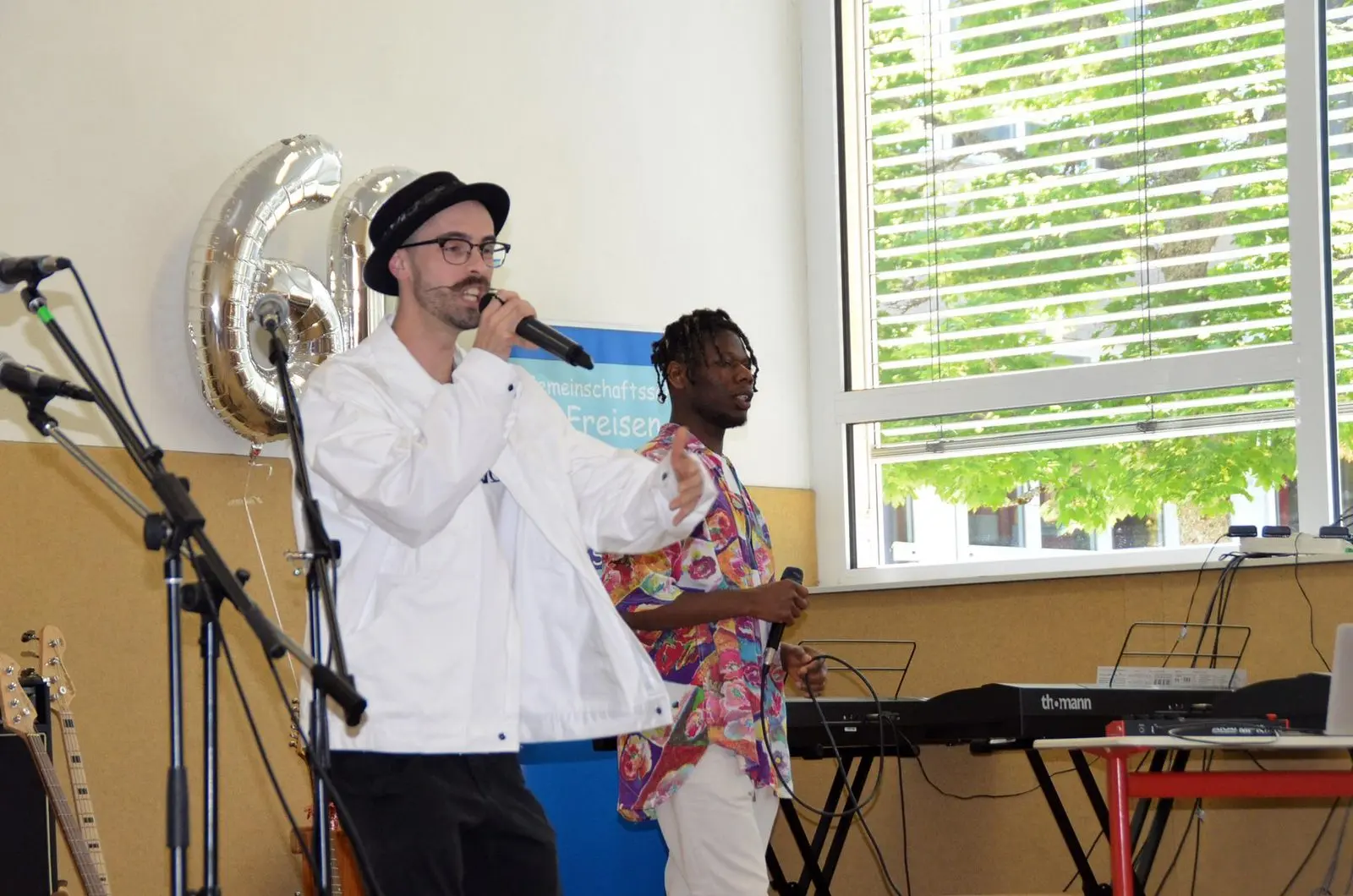 Zwei Sänger auf der Bühne vor Ballons in Form der Zahl 60