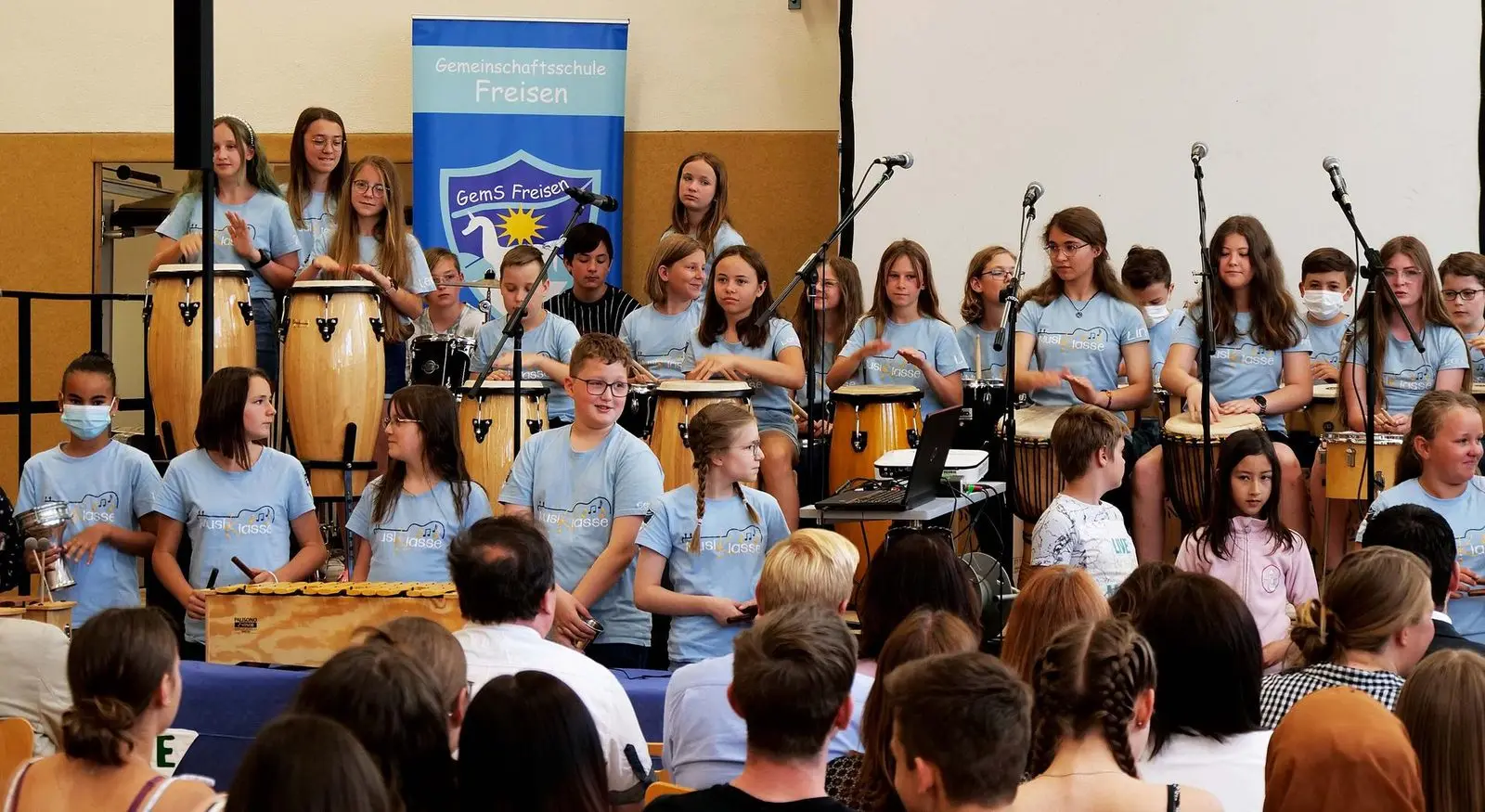 Musikklasse mit Trommeln und Mikrofonen auf der Bühne