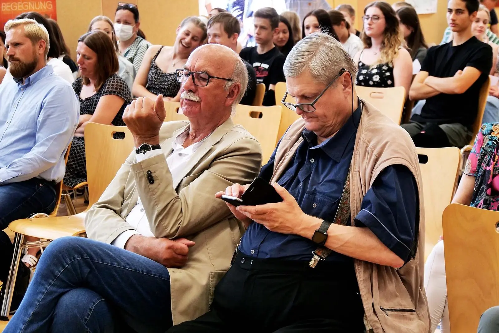 Gäste im Publikum, vorne zwei ältere Männer