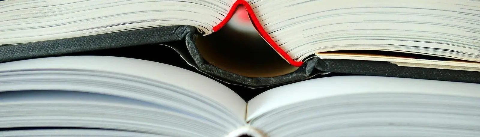 Zwei aufgeschlagene Bücher übereinander, Nahaufnahme