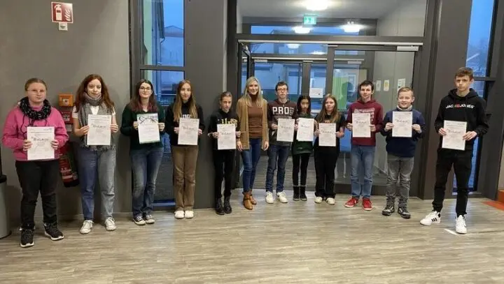 Reihe von Schülerinnen und Schülern mit BioLogo-Urkunden, in der Mitte eine Erwachsene