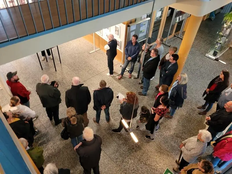 Blick von oben auf Besuchergruppe vor Stellwänden bei der Ausstellungseröffnung