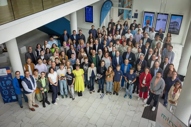 Großes Gruppenfoto vieler Menschen im Foyer, von oben aufgenommen
