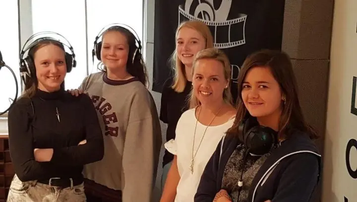 Fünf Sängerinnen mit Kopfhörern im Tonstudio