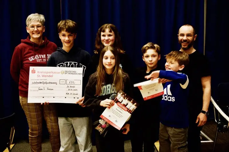 Schülerinnen, Schüler und zwei Erwachsene mit Urkunden und einem Scheck der Kreissparkasse über 625 Euro