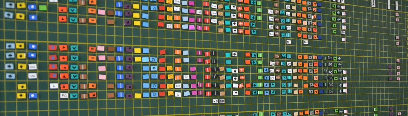Ausschnitt einer großen Plantafel mit vielen bunten Steckkärtchen und Symbolen im Raster