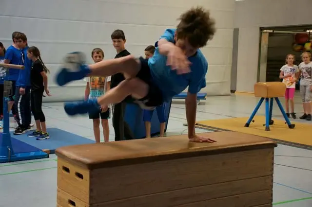Schüler springt in der Turnhalle über einen Kasten