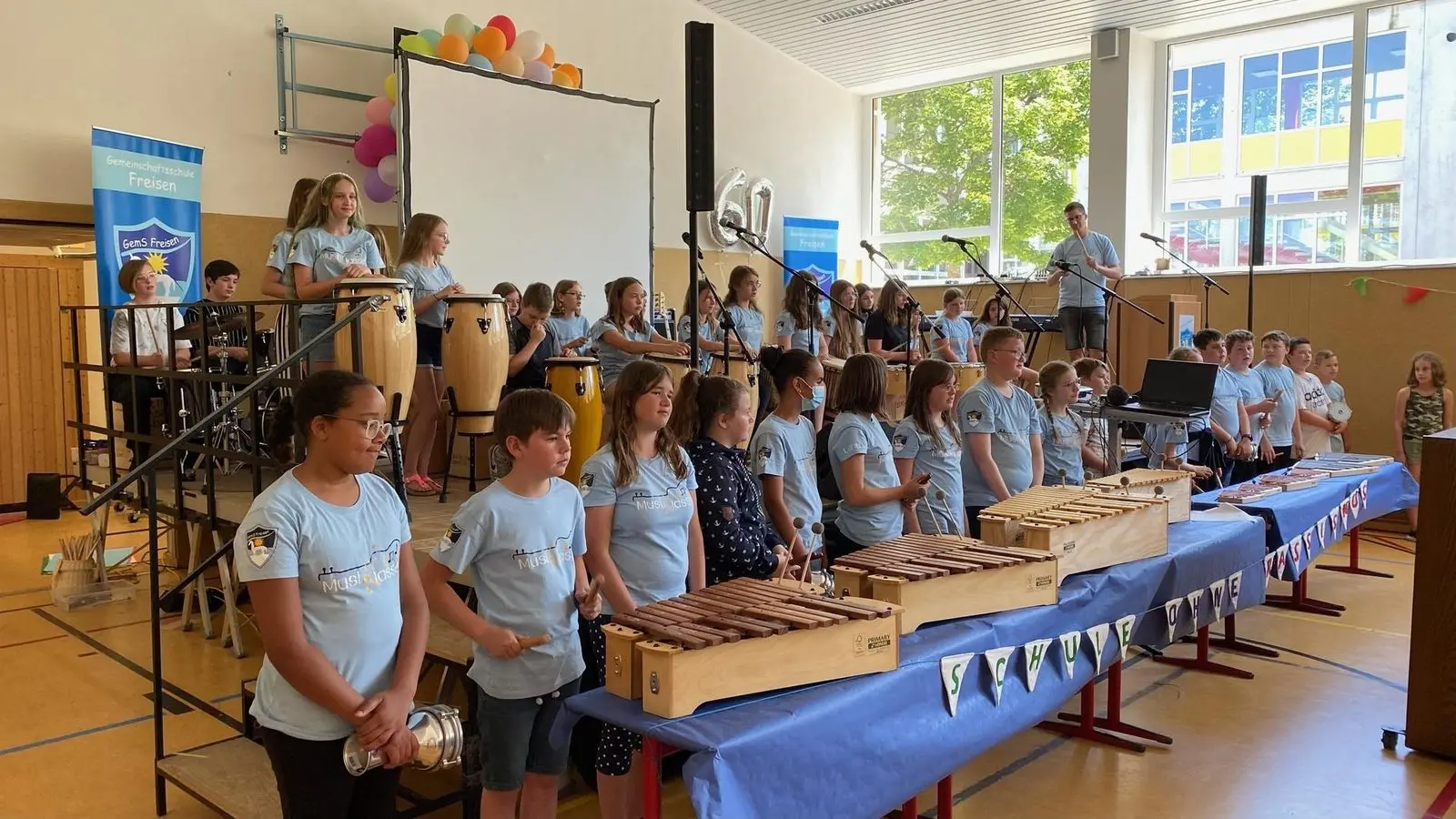 Schülerinnen und Schüler der Musikklasse an Instrumenten auf der Bühne